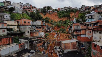 Rescuers remove mud to reach homes buried by a landslide caused by heavy rains homes in Franco da Rocha, Sao Paulo state, Brazil. At least 18 people dead were killed by the storms. AFP
