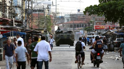 A police armoured vehicle drives through the Mare favela cluster during a police raid. (Marcelo Sayao / EPA / March 30, 2014)