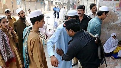 Police stand guard outside a mosque during Eid Al Fitr prayers yesterday in Peshawar.