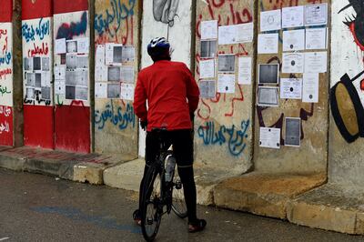 A man looks at university degrees placed by Lebanese unemployed graduates on a roadblock. EPA