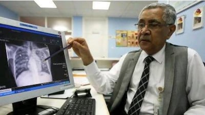 Dr . Mirza Al Sayegh, a consultant physician at the Dubai Health Authority, points out lung scarring from tuberculosis on a chest X-ray.