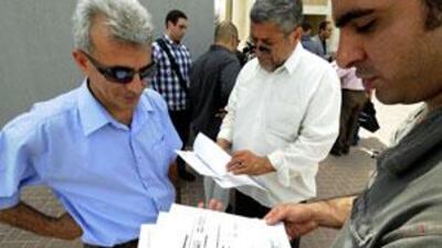 Property investors Masood Saeedi, left, Saeed Saeedi, centre, and Farhad Norouzi, right, go over their documents before going to the office of Casamia Star LLC with 12 other investors to complain.