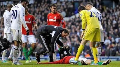 Michu, the Swansea City forward, lies motionless on the pitch after a collision with Tottenham goalkeeper Hugo Lloris, right. Jonathan Brady / PA
