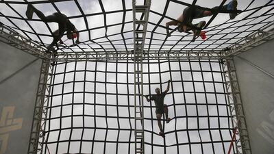 Elite Super participants go through A-frame cargo at XDubai Spartan Race at Al Ghazal Golf Club in Abu Dhabi. Ravindranath K / The National