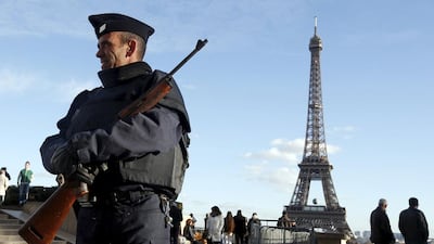 A French police officer stands guard by the Eiffel tower a week after a series of deadly attacks in the French capital Paris (REUTERS/Eric Gaillard)