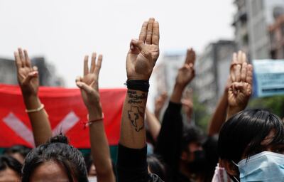 Demonstrators flash three-fingers salutes as they march during an anti-military coup protest in Yangon. EPA