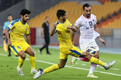 Gharafa's defender Tameem al-Muhaza, centre, vies for the ball with Foolad's midfielder Mohammad Abshak. AFP