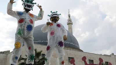 Volunteers dressed in coronavirus-themed costumes gesture as they stand on a vehicle during a campaign organised by the Violet Organisation, in an effort to spread awareness and encourage safety in the rebel-held Idlib city, Syria. Reuters