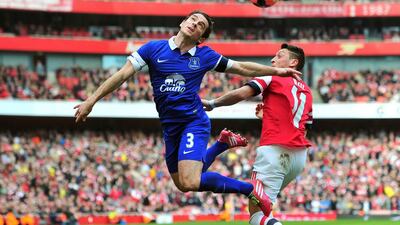 Arsenal’s German midfielder Mesut Ozil, right, vies with Everton’s English defender Leighton Baines during the English FA Cup quarter final football match between Arsenal and Everton at the Emirates Stadium in London on March 8, 2014. Glyn Kirk / AFP