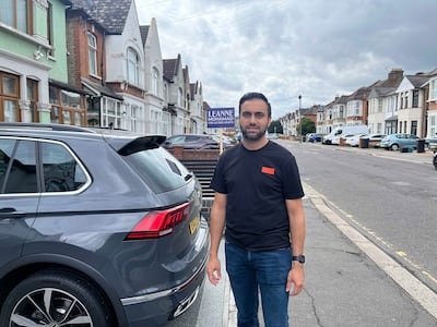 Irman Ibrahim standing in front of a placard showing his support for Leanne Mohamad in Ilford. Tariq Tahir / The National