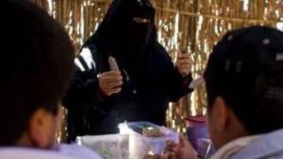 At a workshop held at the Watani Camp, children learn how to make traditional hut models.