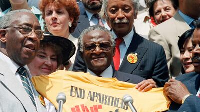 Tutu displays an "End Apartheid" T-shirt at New York's City Hall in 1986. AP