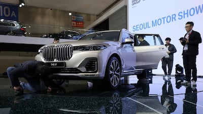 Attendees look at a BMW AG X7 sport-utility vehicle. Seong Joon Cho / Bloomberg