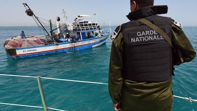 A member of Tunisia's national guard stops a fishing boat in the sea bordering Tunisia and Libya as they check vessels for illegal migrants trying to reach Europe. AFP Photo