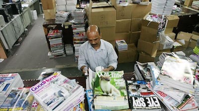 John Matthews censors magazines by crossing out nudity in a warehouse near the port.