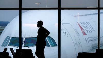 A passenger wears a face mask as they wait for a Delta Airlines flight at Hartsfield-Jackson International Airport in Atlanta. AP