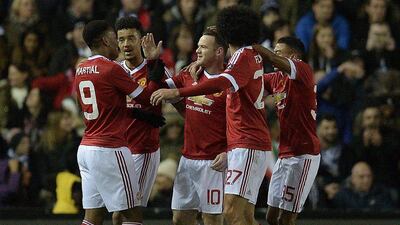 Manchester United's Anthony Martial, left, congratulates teammate Wayne Rooney, centre, for scoring his team's first goal during the FA cup fourth round match against Derby County at Pride Park Stadium in Derby on January 29, 2016. Manchester United won the match 3-1. AFP / OLI SCARFF
