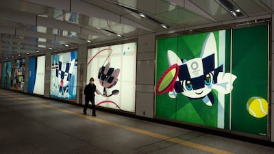 A man walks past large displays promoting the Tokyo 2020 Olympics in Tokyo on Monday. AP