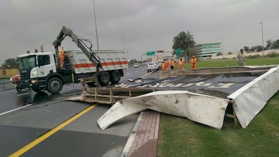 Workers remove a billboard from the street. Courtesy Dubai Municipality