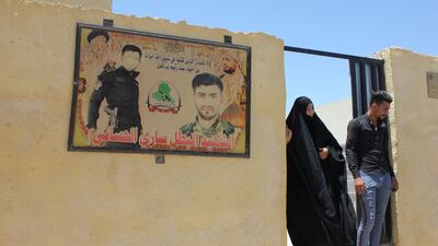 Sahla AlHasani and her son outside their house funded by Asaib Ahl Al Haq. Lizzie Porter/ The National