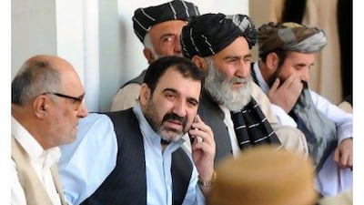 Ahmed Wali Karzai, centre, pictured talking on the phone in 2009 as he sits with supporters celebrating the re-election victory of his brother President Hamid Karzai. BANARAS KHAN / AFP PHOTO