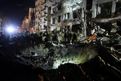 Israeli emergency responders inspect a crater at the site of a projectile impact after Iran launched missiles into Israel. Reuters