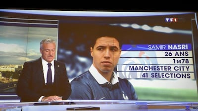 Didier Deschamps announces the 2014 World Cup France squad on French television Tuesday night. Samir Nasri, pictured on screen, was not included. Franck Fife / Reuters / May 13, 2014