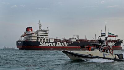 A speedboat of Iran's Revolutionary Guard passes the British-flagged oil tanker Stena Impero in Bandar Abbas port, where the ship has been detained since July. Mizan News Agency via AP
