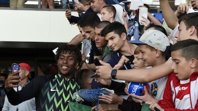 Nigeria forward Alex Iwobi poses for selfies with fans at the team's first training session at Essentuki Arena in southern Russia ahead of 2018 World Cup. AFP