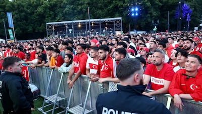 Police officers look on as Turkey fans watch Netherlands vs Turkey in a fanzone at the Brandenburg gate in Berlin. Reuters