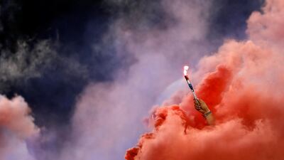 A Chivas fan holds a torch as red smoke fills the stands during the second half of the team's Colossus Cup soccer match against River Plate in San Diego. AP