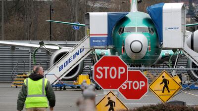 A Boeing worker walks in view of a 737 MAX jet in Renton, Washington. The company has disclosed a new set of 737 Max-related messages to FAA. AP
