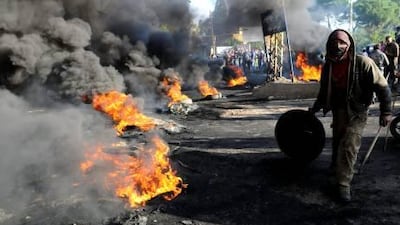 A protester burns tires in the northern Akkar region, Lebanon as thousands of Sunnis protested against the failure of Saad Hariri to be reappointed the country's PM.