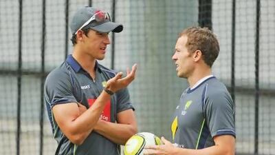 Australia fast bowlers Mitchell Starc and Peter Siddle chat during training.