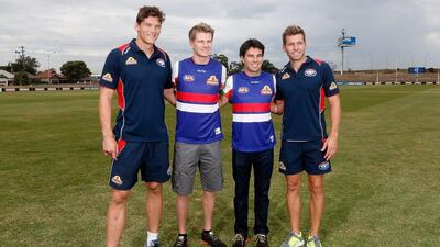 Formula One drivers Nico Hulkenberg, second left, and Sergio Perez, second right, pose for a photograph with Australian Rules Football players Will Minson, far left, and Shaun Higgins, far right. Darrian Traynor / Getty Images