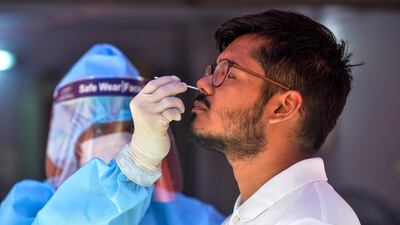 A health official collects nasal swab samples from a man for a Covid-19 test at a primary health centre in Siliguri. AFP