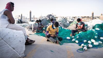 A group of men make fishing nets at Jumeirah fishing harbour in late March during the temporary closure of the Dubai fish market. Reem Mohammed / The National