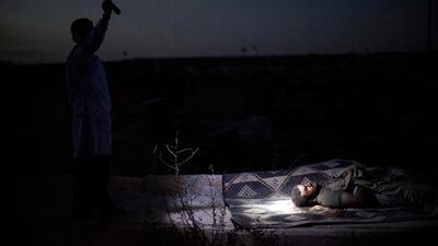 Day or night, the killings continue. Here, at a graveyard, in Aleppo. a man points a torch towards the body of a recently killed man.