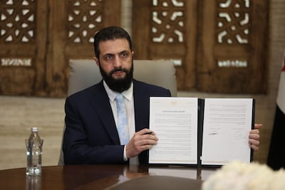 Syrian President Ahmad Al Shara shows the ceasefire agreement he signed with the SDF on Sunday. Getty Images