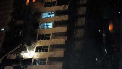 Members of the Civil Defence work to extinguish a fire at residential buildings in the Sowan area of Ajman. Ali Haider / EPA