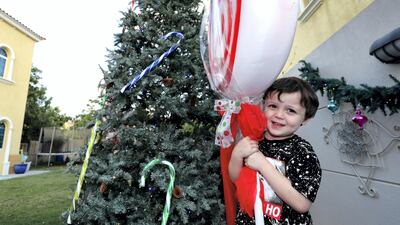 Baxter hugs a giant lollipop in the outdoor area, which features a 3.6-metre Christmas tree