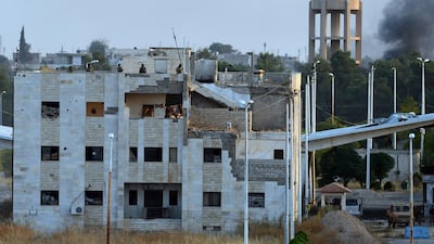 Fighters of Turkey-backed Syrian opposition force secure the area atop a building in Syrian town of Tal Abyad. AP