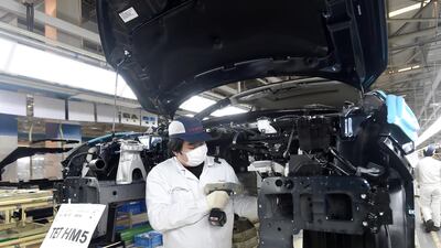 A worker wearing a face mask works on an assembly line at a Dongfeng Honda plant in Wuhan. China's manufacturing rebounded in March as authorities relaxed anti-disease controls. Chinatopix via AP