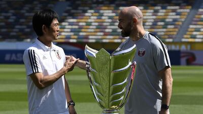 Japan's head coach Hajime Moriyasu, left, shakes hands with Qatar's head coach Felix Sanchez, right, during a photo session at the Zayed Sports City Stadium in Abu Dhabi ahead of their Asian Cup's final football match. AFP