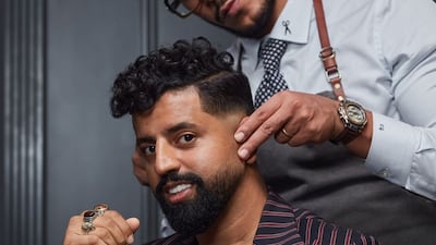 Carlos Gamal, the owner and founder of CG Barbershop in Dubai, with a customer. Photo: CG Barbershop