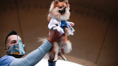The winner of the New York first responders dog costume contest holds his dog in a medical coat. AFP
