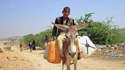 A Yemeni youth commutes on a donkey carrying jerrycans of water at a camp for internally displaced people by conflict in the northern Hajjah province on October 12, 2020. AFP