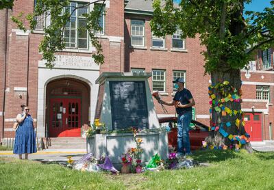 People lay flowers in front of the administration building at the former Kamloops Indian Residential School, in British Columbia, Canada, after the remains of 215 children were found. Reuters