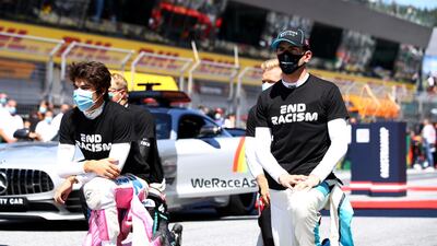 Lance Stroll and Nicholas Latifi kneel on the grid ahead of the Austrian Grand Prix. Reuters