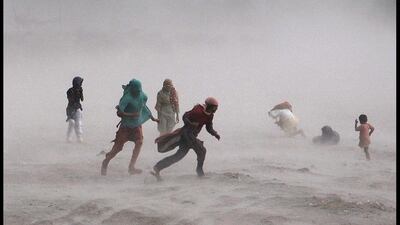 People fight their way through a storm near the Ravi river in Lahore, Pakistan. Arif Ali / AFP Photo